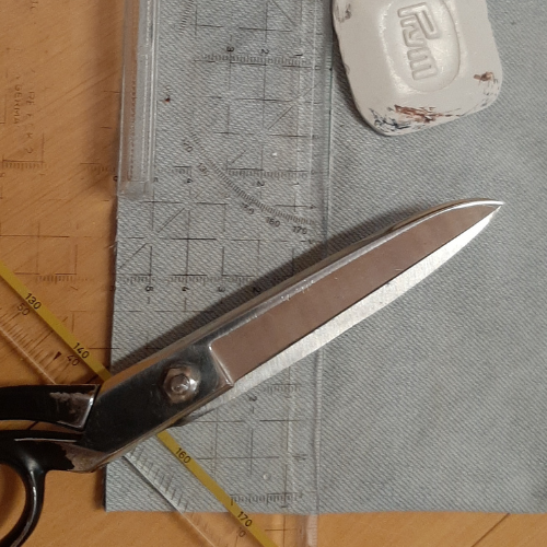 Foto zum ersten Schritt für eine selbstgenähte Bechermanschette: Schere, Lineal und Kreide auf Jeansstoff