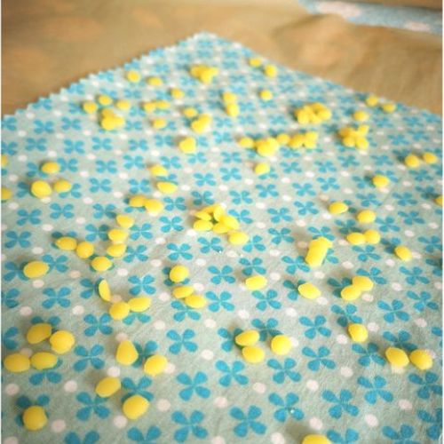 Foto zum zweiten Schritt für ein selbstgemachtes Wachstuch: Wachspastillen auf einem Tuch