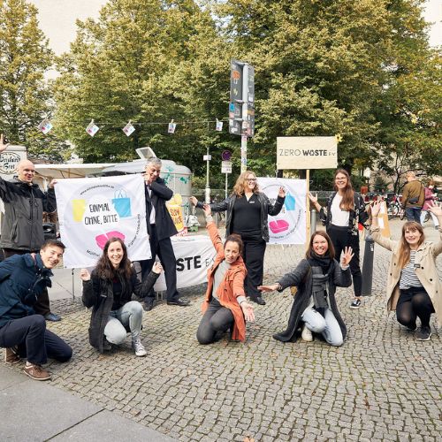 Foto einer Gruppe jubelnder Personen mit zwei Bannern von „Einmal ohne, bitte“ auf einem Berliner Platz