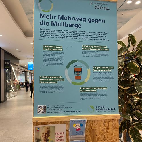 Foto eines Plakats mit dem Titel „Mehr Mehrweg gegen die Müllberge“; darunter Flyer von „Einmal ohne, bitte“