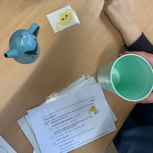 Foto mit Rollenspiel-Karten und Teekannen-Symbol auf einem Tisch